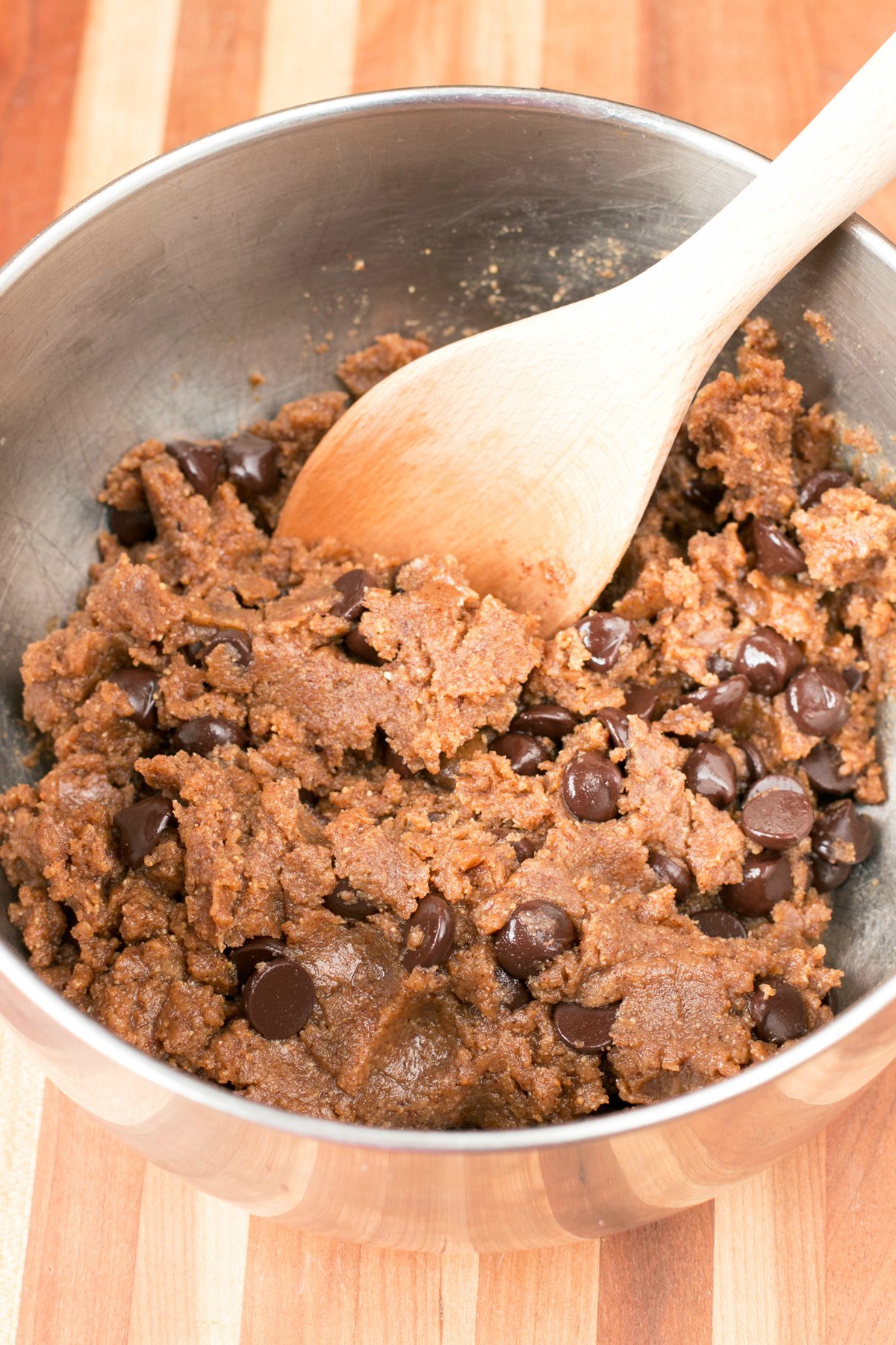 Large stainless steel mixing bowl filled with almond butter chocolate chip cookie dough