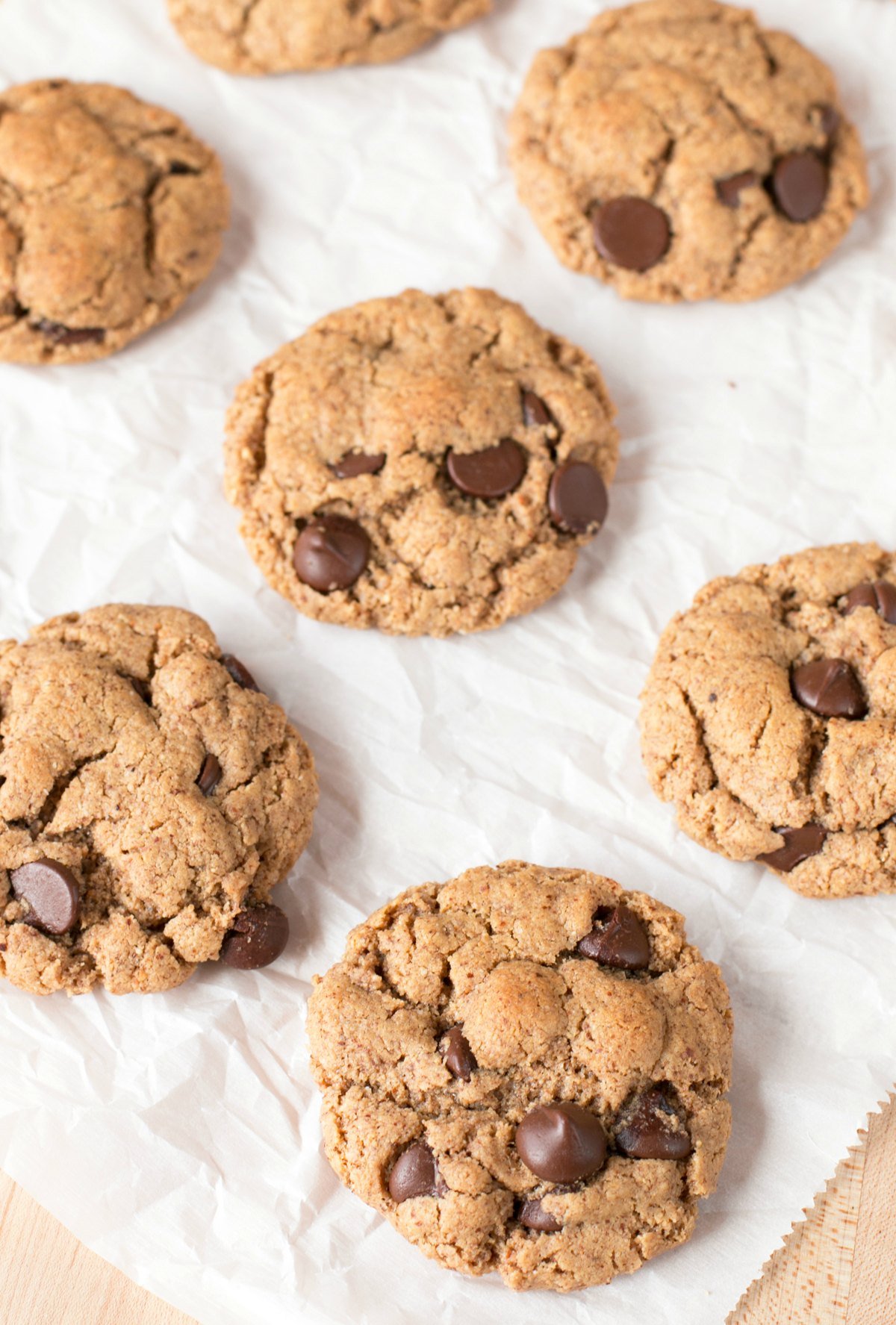 Overhead picture of almond butter cookies with chocolate chips cooling on waxed paper