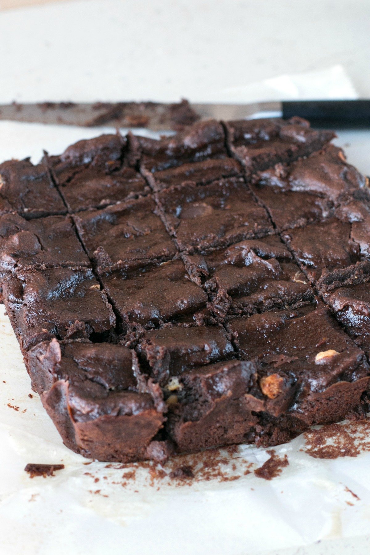 Triple Chocolate Avocado Brownies sliced into squares on parchment paper