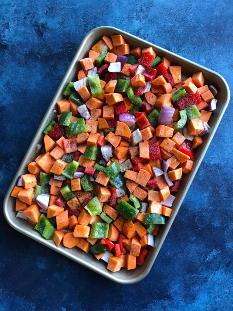 Sweet Potatoes, peppers, and onions on a baking sheet 