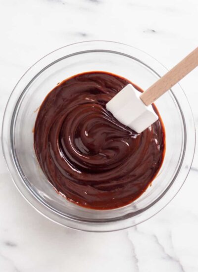 Mixing chocolate ganache in a bowl with a spatula.