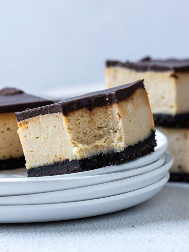 Chocolate Peanut Butter Cheesecake Bar on a plate with a bite taken out of it.