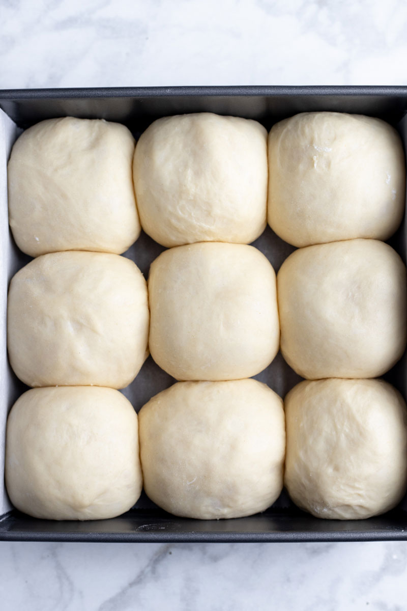 Hawaiian sweet roll dough proofing in a tray.