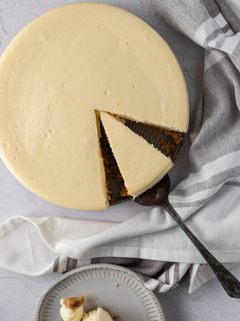 Cheesecake with a slice being cut out.