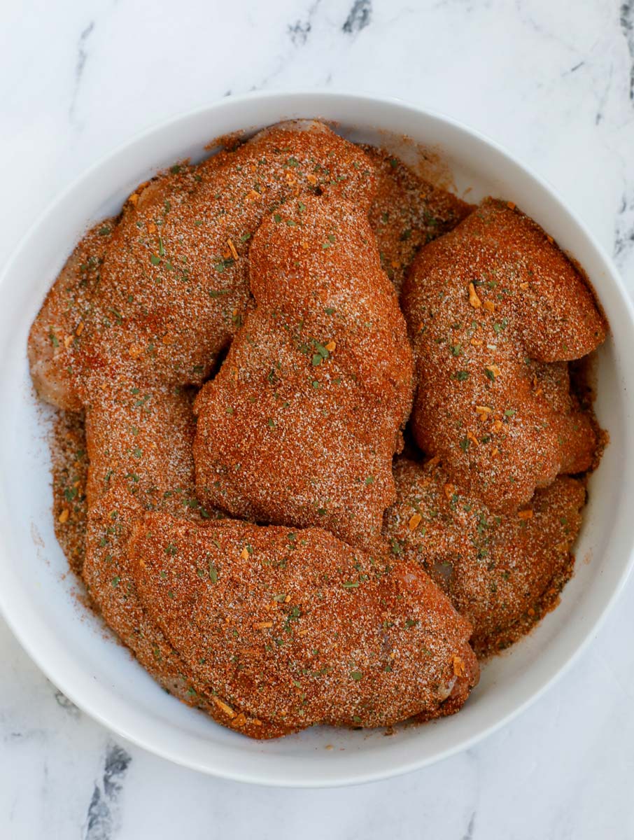 Raw chicken thighs in a bowl. 