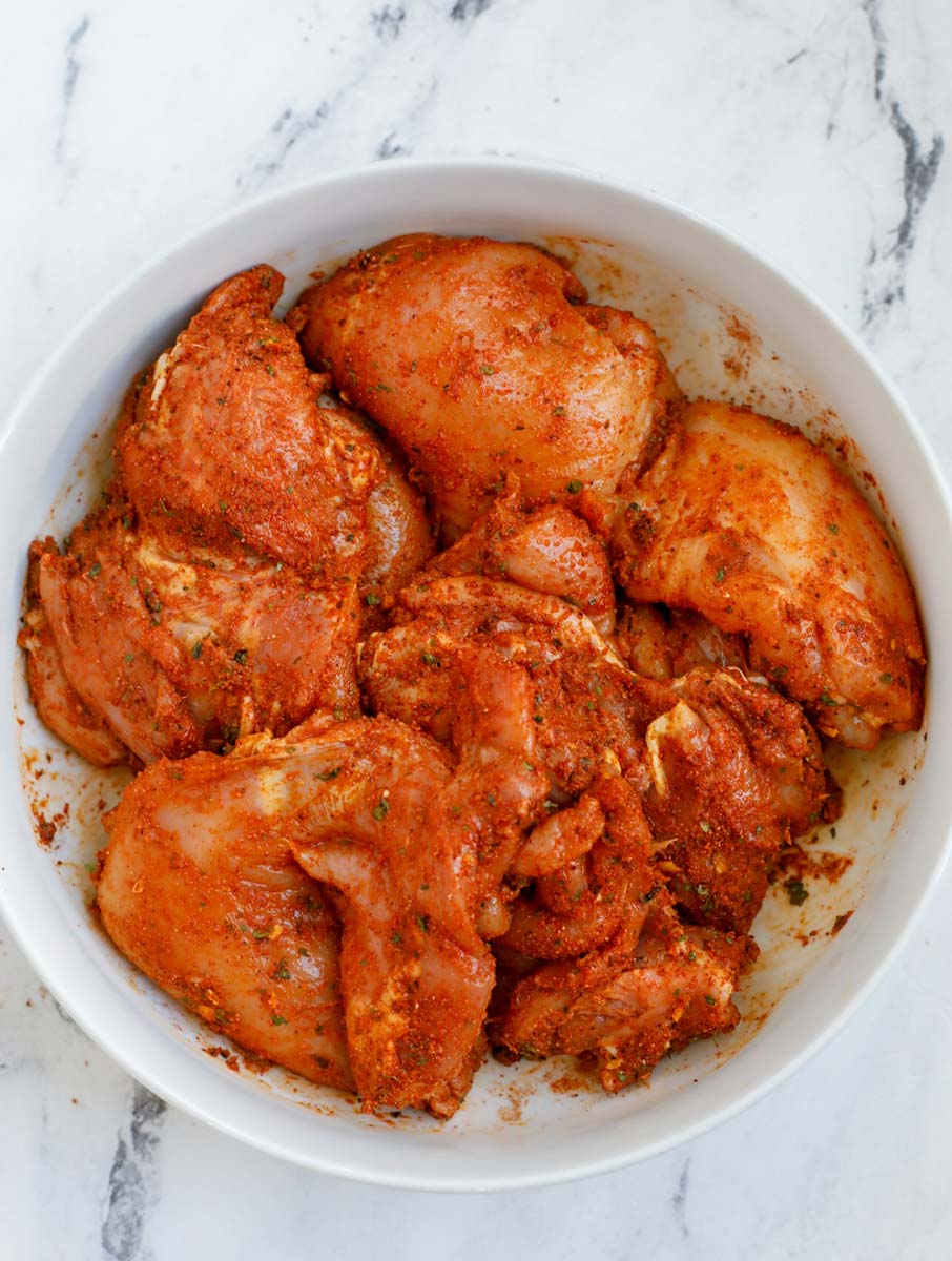 Chicken thighs marinating in a bowl. 