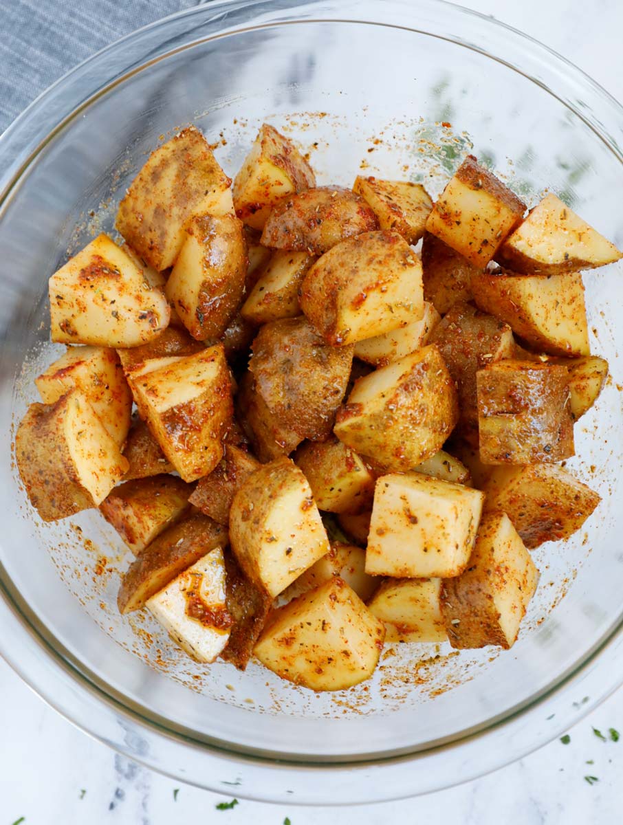 Seasoned potatoes before air frying.