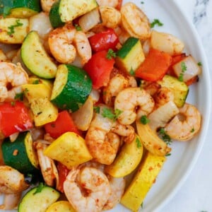 Top down shot of air fryer shrimp and vegetables on a plate.