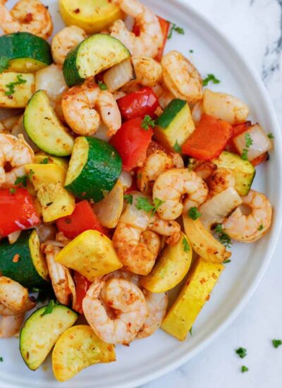 Top down shot of air fryer shrimp and vegetables on a plate.