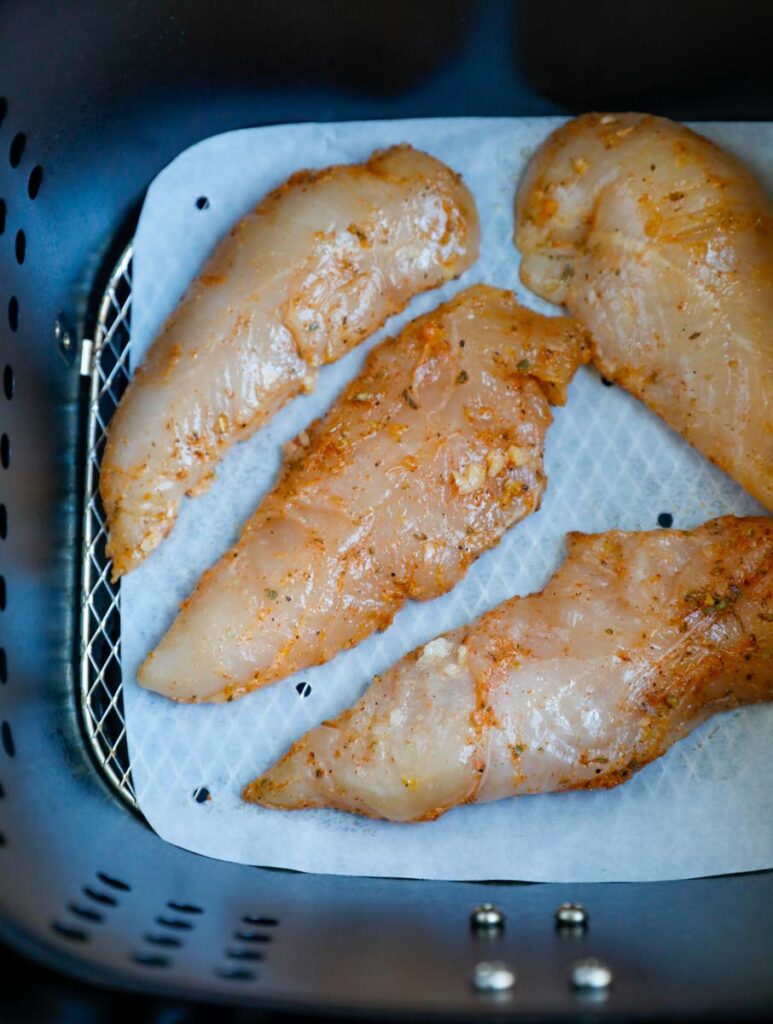 Raw chicken in an air fryer.