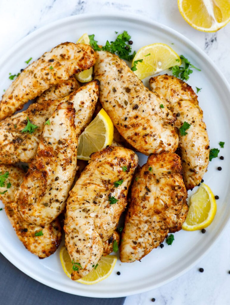 Top down view of lemon pepper chicken on a plate.