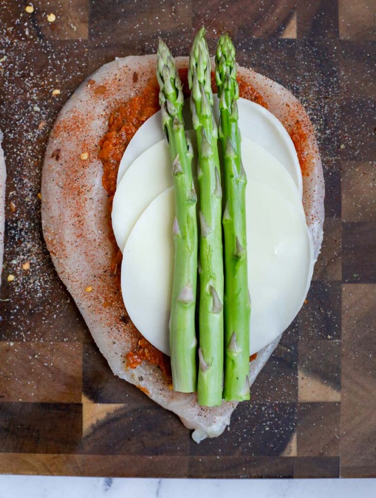 Chicken breast with pesto, cheese and asparagus.