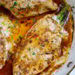 Top down shot of asparagus stuffed chicken breasts in a skillet.