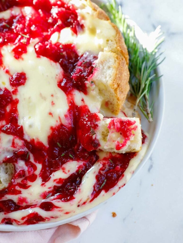 Baked brie cranberry bread bowl with the cheese melting.