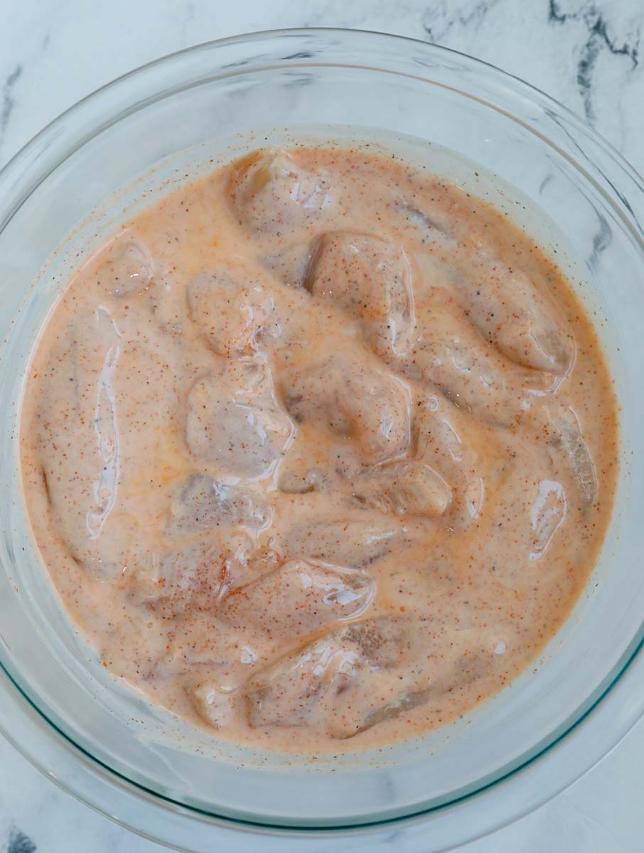 Overhead shot of tenders marinating in a bowl.