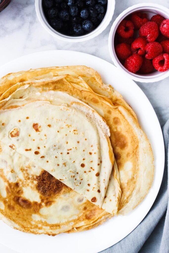 Top down shot of the best crepes on a white plate.