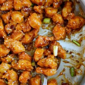 Close up of a spoonful of crispy general tso chicken.