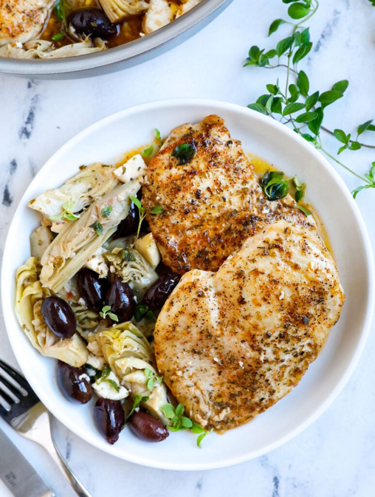 greek chicken breasts served on a white plate
