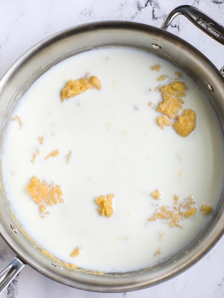 Adding milk to a pan.