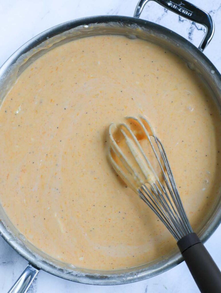 Whisking sauce ingredients together for Buffalo chicken mac and cheese.