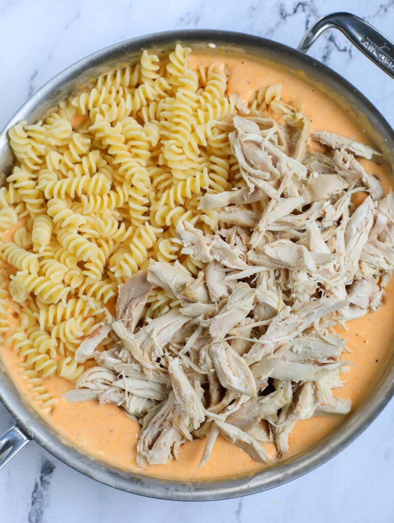 Pasta and chicken in pot with sauce.