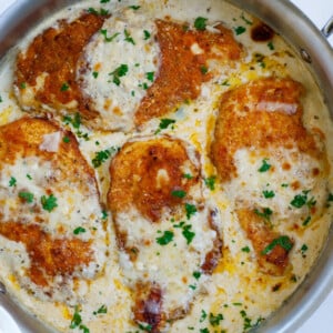 Caesar chicken in a creamy sauce in a skillet.