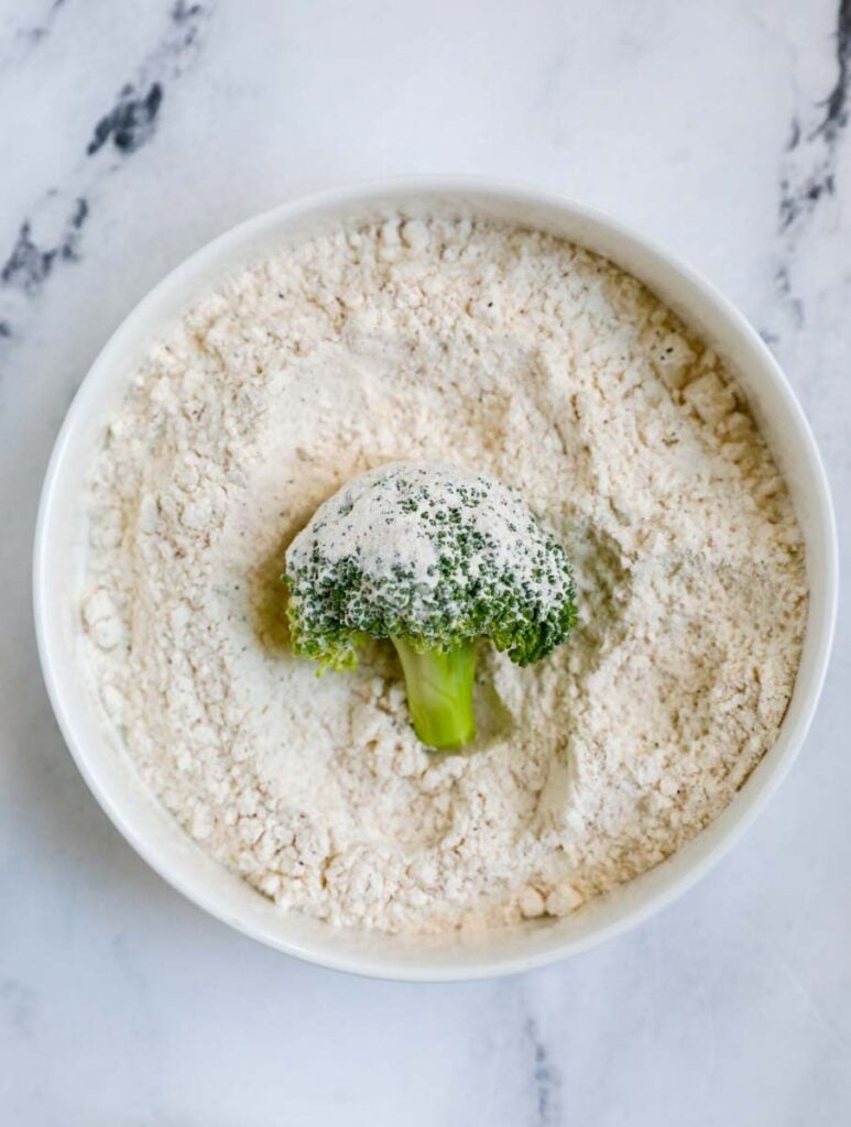 broccoli in a bowl of flour.