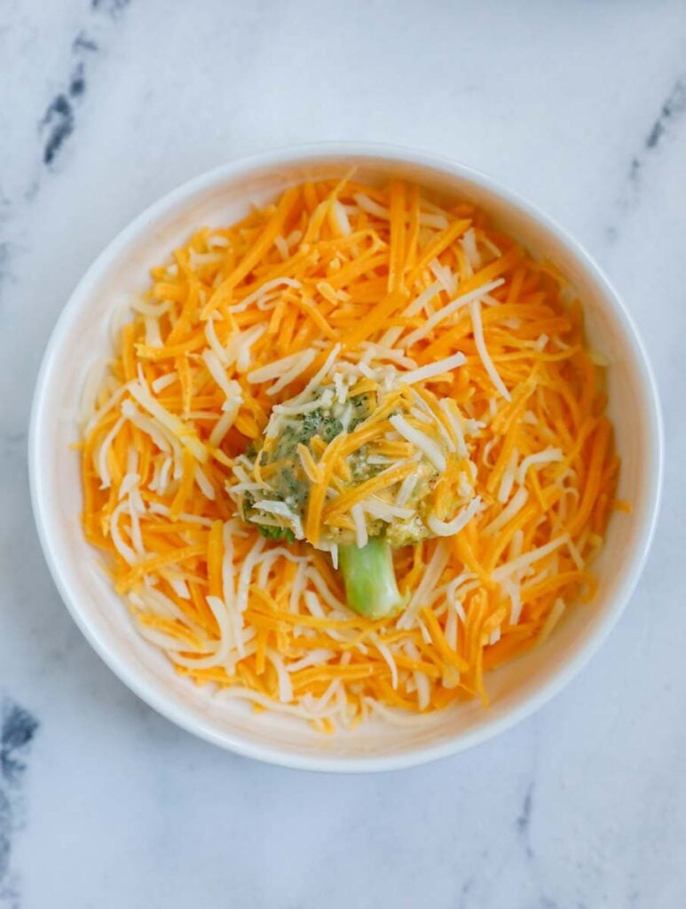 Broccoli in a bowl of cheese.