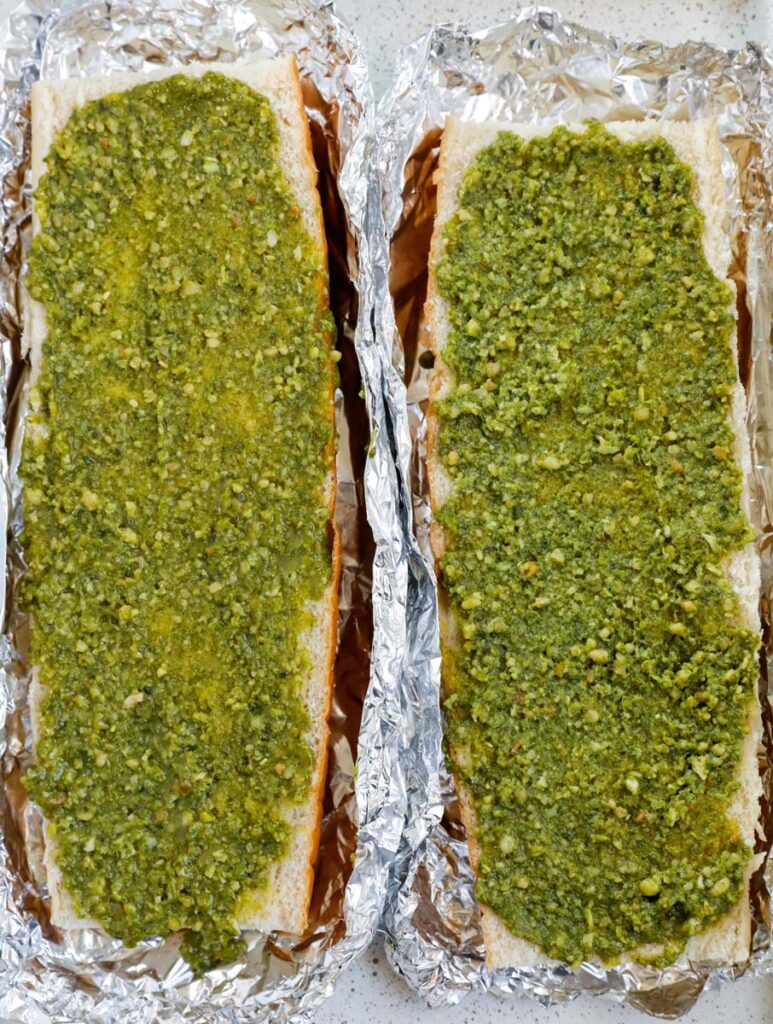 Slices of bread covered with a layer of pesto. 