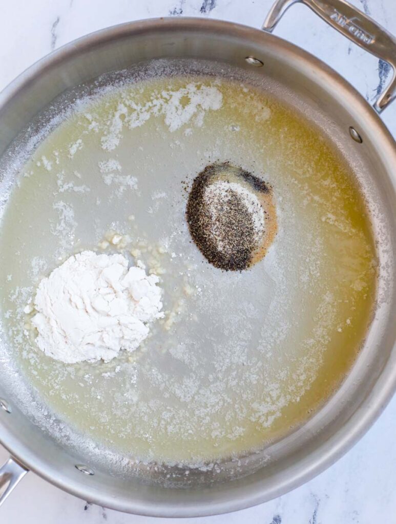 Melted butter, oil, spices, and flour in a silver skillet.