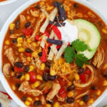 A top down photo of a bowl of chicken enchilada soup.