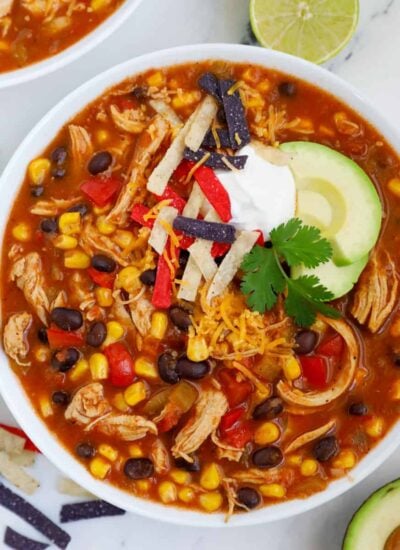 A top down photo of a bowl of chicken enchilada soup.