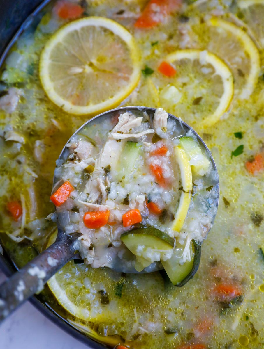 Soup being scooped out in a ladle.