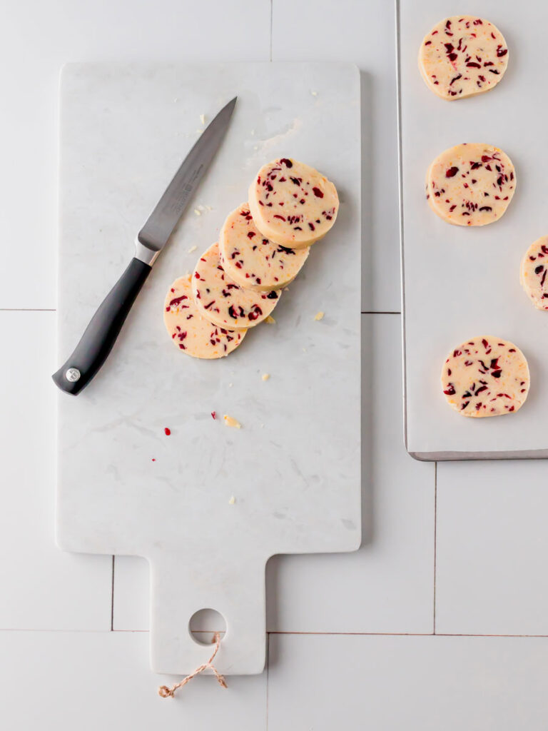 Overhead view of cookie shapes cut from the log of dough.