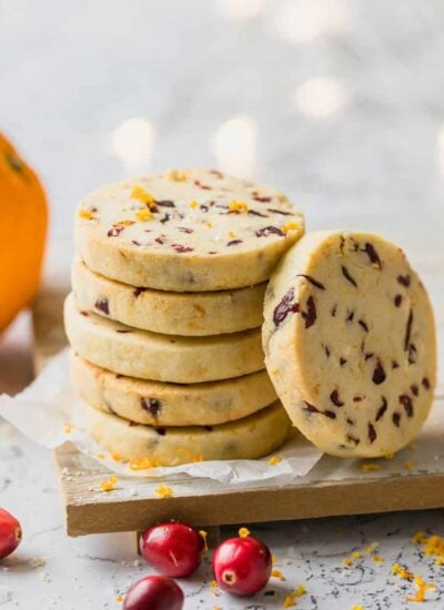 A stack of shortbread cookies surrounded by cranberries.