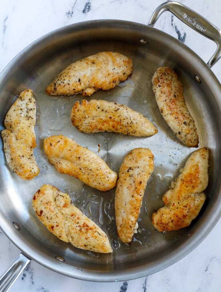 Top down shot of chicken tenders in a pan.