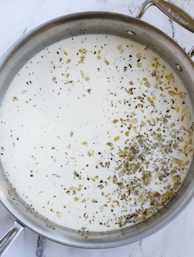 Adding cream to a pan.
