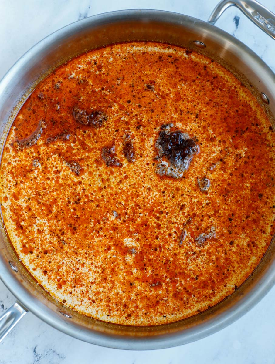 Making cajun cream sauce in a skillet.