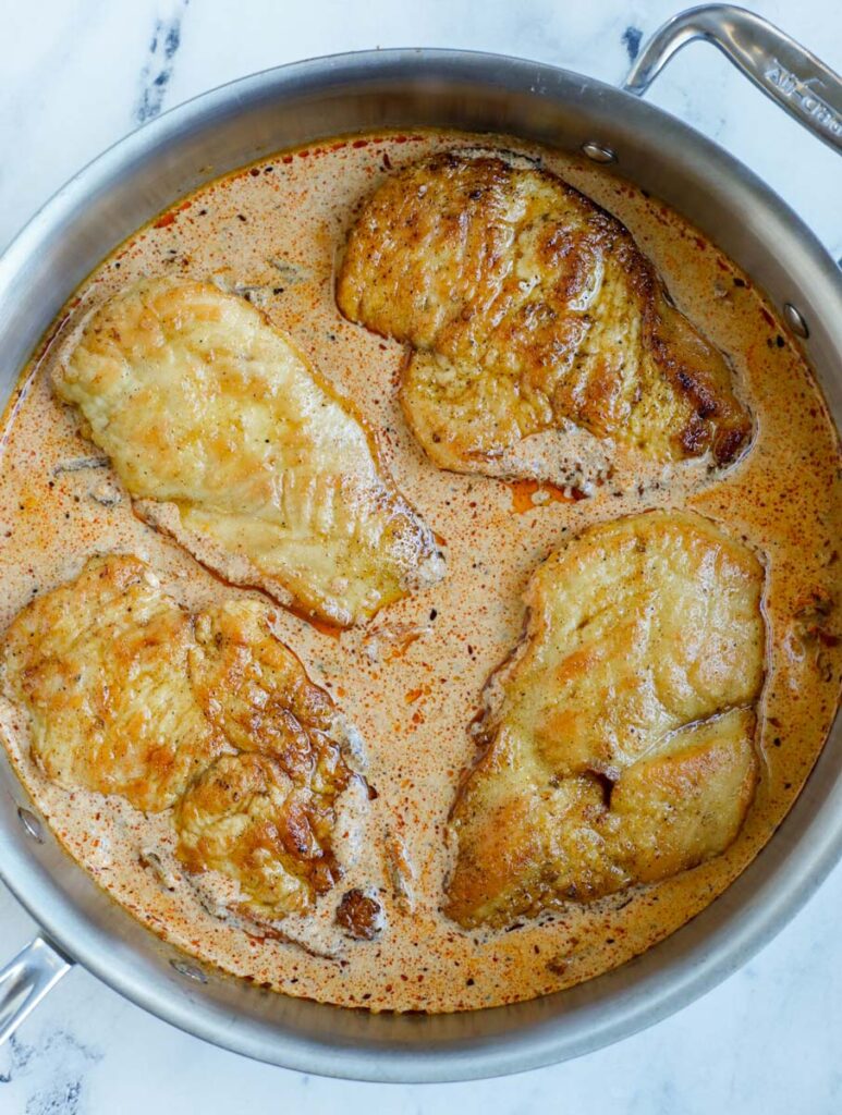 Creamy cajun chicken breasts inside of a skillet.