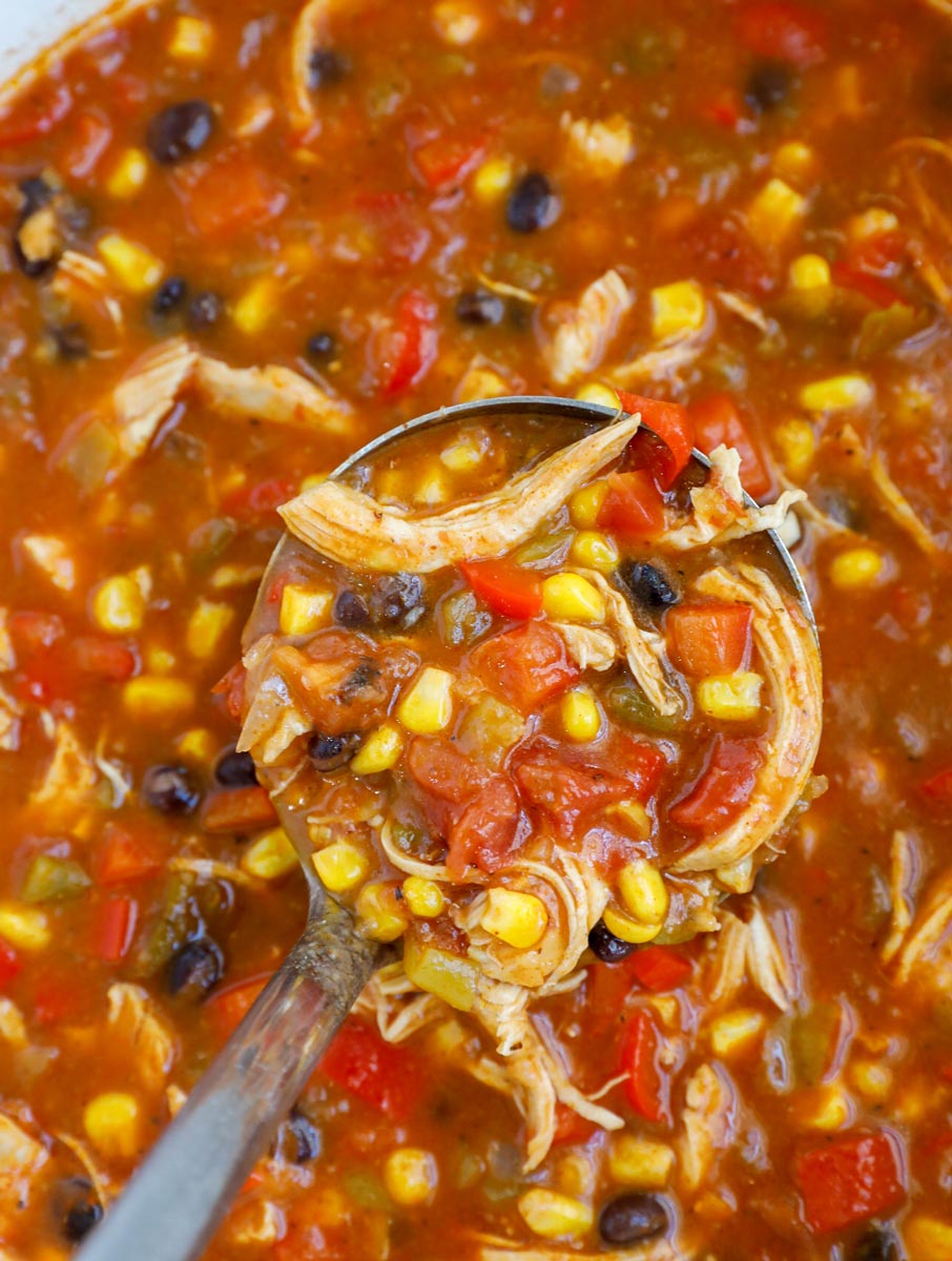 A ladle scooping out enchilada soup.