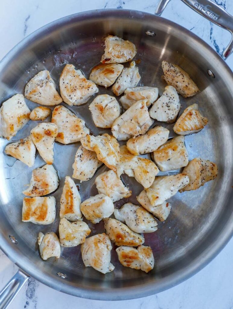 Chicken cubes cooked in a pan.