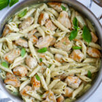 Creamy pesto chicken pasta in a pan.