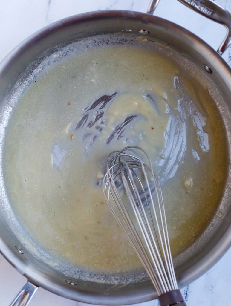 Whisking a roux in a pan.