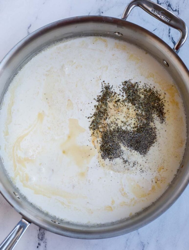 Making a creamy sauce in a pan seasoned with garlic powder, onion powder, and pepper.