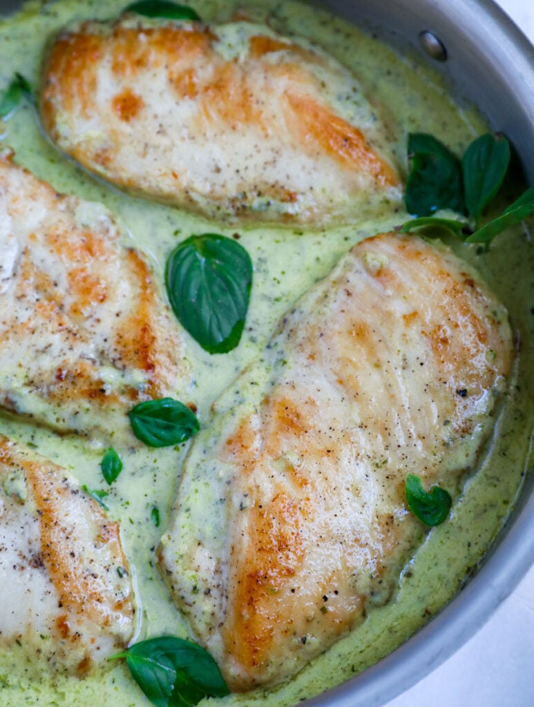 Overhead view of creamy pesto chicken in a skillet.