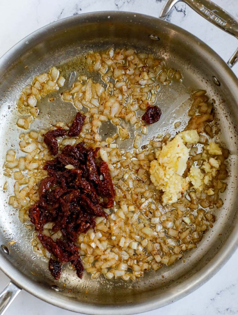 to down view of sautéed onions, garlic and sundried tomatoes