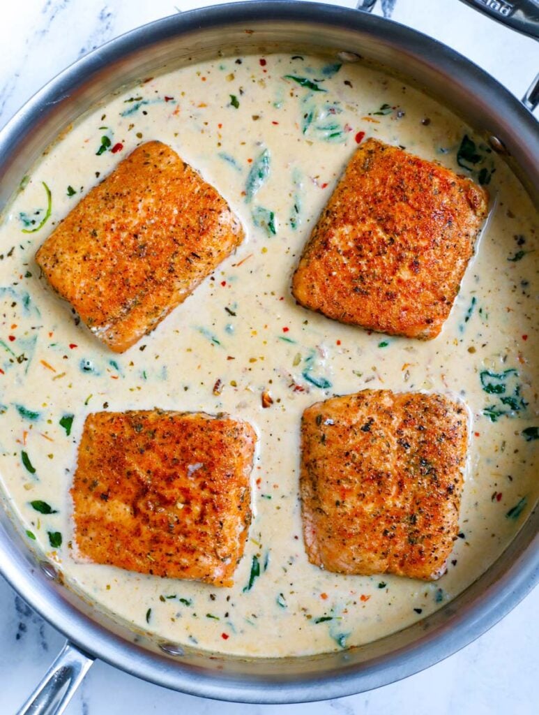 Overhead shot of salmon fillets in cream sauce.