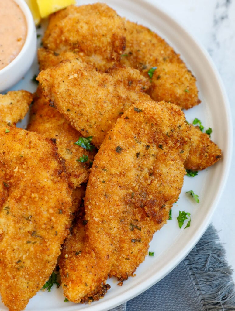 Top down view of chicken tenders on a plate.