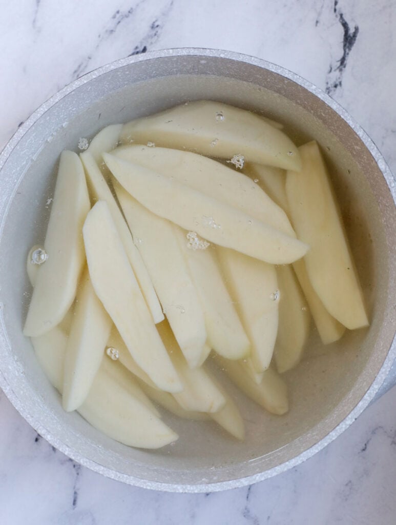 potatoes in pot with water, ready to boil