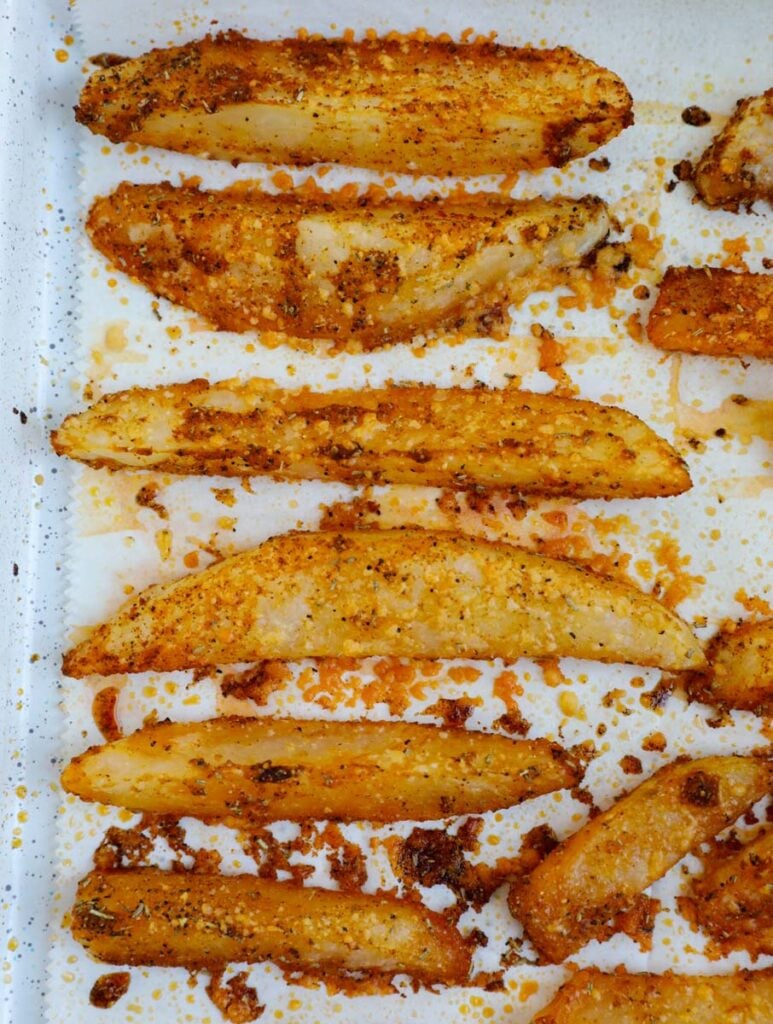 Crispy potato wedges on a baking sheet.